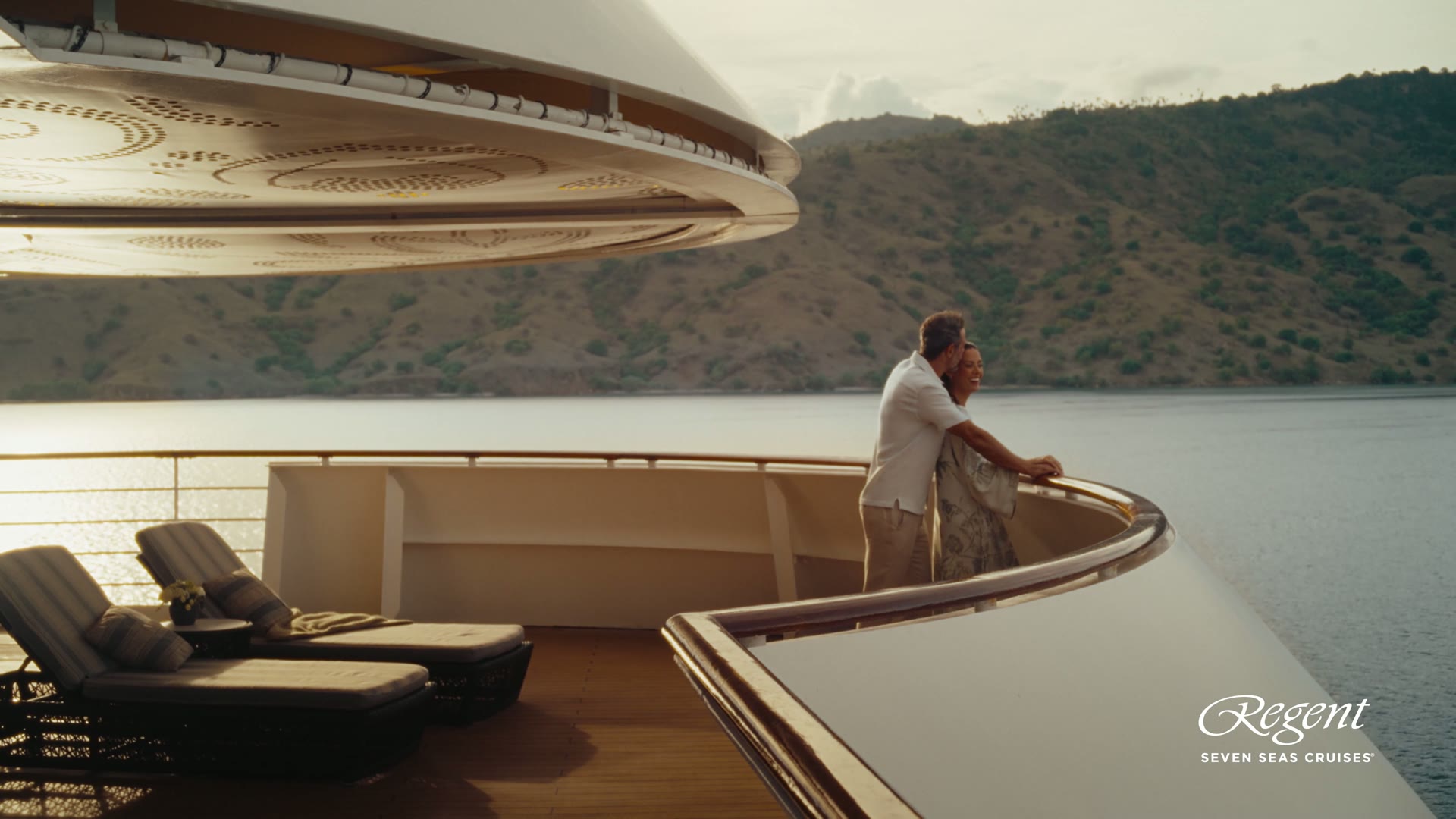 The interior of a Regent Seven Seas suite with seating area and ocean view