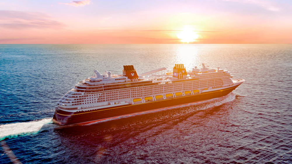 Disney Wish sailing across the ocean at sunset