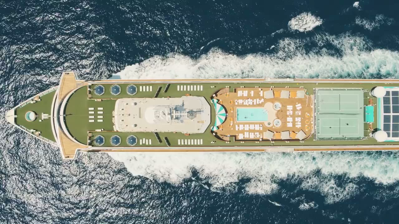 Film still from Crystal's 2028 World Cruise announcement: the ship at golden hour with tropical islands beyond