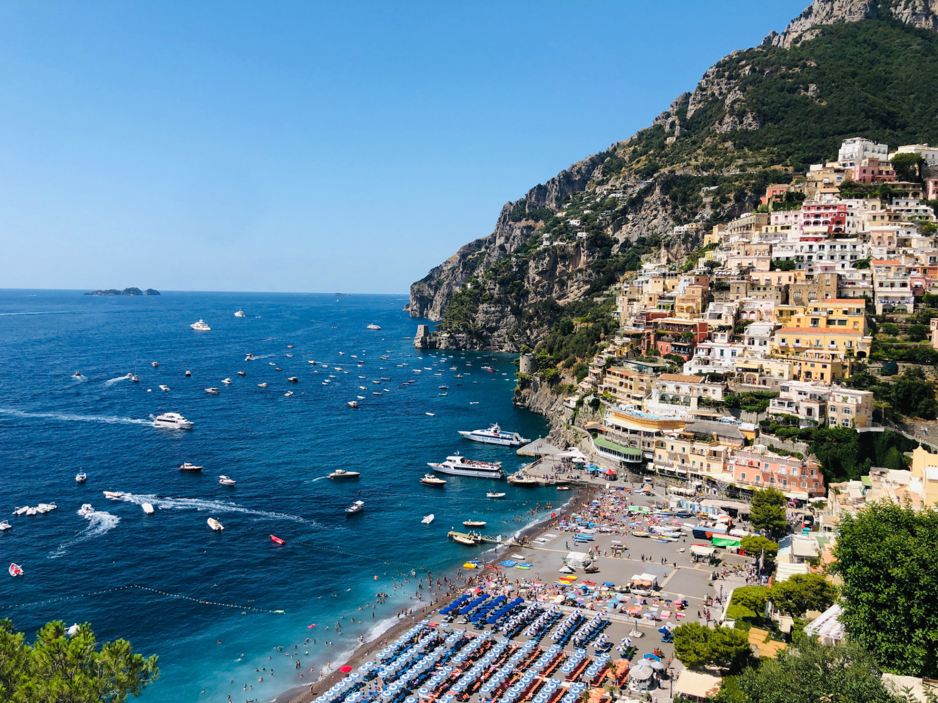 Positano on the Amalfi Coast, colorful buildings stacked above the beach with boats in the bay